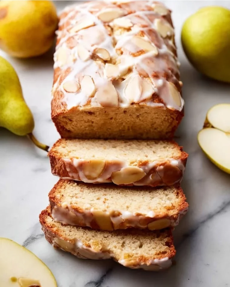 Delicious baked pear bread topped with almond glaze, perfect for dessert or breakfast.